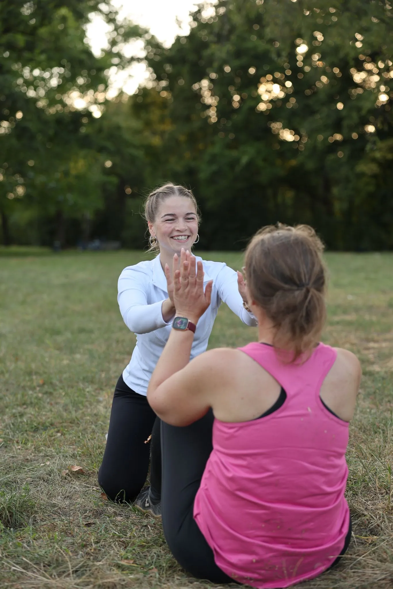 Jessica Bülow gibt einer Klientin nach einer Übung im Park ein High five